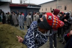 FILE - A Kashmiri boy throws rocks at a police drone over Jamia Masjid mosque where Kashmiris were offering their first Friday prayers since Aug. 5 in Srinagar, Kashmir, Dec. 20, 2019. The mosque was shut Aug. 5 as part of India's security lockdown.