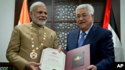 Palestinian President Mahmoud Abbas, right, decorates Indian Prime Minister Narendra Modi with the Grand Collar of the State of Palestine medal, during his visit to the Palestinian Authority headquarters in the West Bank city of Ramallah, Feb. 10, 2018.