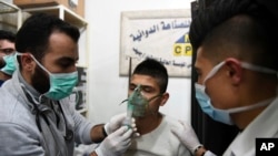 This photo released by the Syrian official news agency SANA shows a man receiving oxygen through respirators following a suspected chemical attack on his town of al-Khalidiya, in Aleppo, Syria, Nov. 24, 2018. 