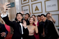 The cast of "Parasite" pose for a selfie on the red carpet during the Oscars arrivals at the 92nd Academy Awards in Hollywood, Los Angeles, California, Feb. 9, 2020.