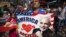 A supporter holds up an America Loves Modi sign as he assembles with a large crowd of people in Times Square to watch the speech by India's Prime Minister Narendra Modi simulcast in New York, Sept. 28, 2014. 