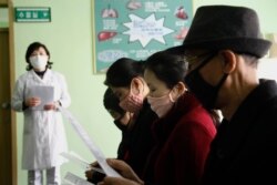 FILE - People review information explaining the COVID-19 coronavirus at the Phyongchon District People's Hospital in Pyongyang, North Korea, April, 1, 2020.