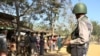 Seorang tentara Myanmar berdiri menjaga sekelompok pengungsi Rohingya di depan rumah mereka di sebuah desa di negara bagian Rakhine pada 25 Januari 2019. (Foto: AFP/Richard Sargent)