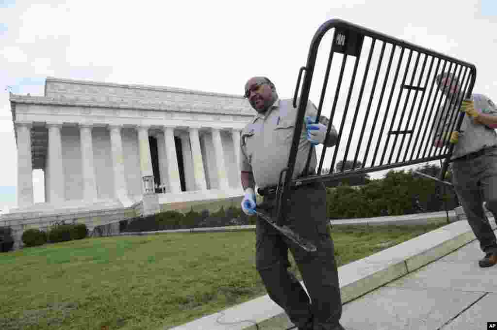 Pegawai Dinas Taman Nasional memindahkan barikade dari Tugu Peringatan Lincoln di Washington (17/10). (AP/Susan Walsh)