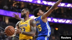 LeBron James, à gauche, contre le pivot Damian Jones des Golden State Warriors, Las Vegas, Nevada, le 10 octobre 2018. (Stephen R. Sylvanie-USA TODAY Sports). 