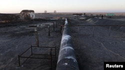 FILE - Damaged tanks and pipelines are seen at the oil port of Ras Lanuf, Libya January 11, 2017.