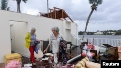 A Bayou West resident and friend try to salvage items from her home after an apparent tornado touched down on the central beach community after Hurricane Milton in Vero Beach, Fla., Oct.11, 2024. (Kaila Jones/USA Today Network via Reuters)