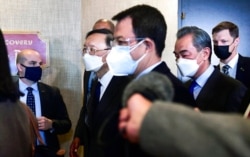 FILE - Top Chinese diplomat Yang Jiechi, second from left, and Chinese Foreign Minister Wang Yi, second from right, depart from the closed-door morning session of U.S.-China talks in Anchorage, Alaska, March 19, 2021.