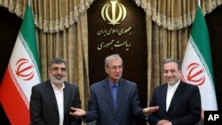 FILE - From left to right, spokesman for Iran's atomic agency Behrouz Kamalvandi, Iran's government spokesman Ali Rabiei and Iranian Deputy Foreign Minister Abbas Araghchi, attend a press briefing in Tehran, July 7, 2019.