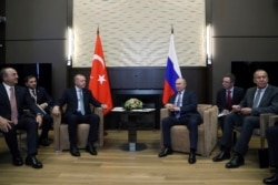 FILE - Russian President Vladimir Putin and Turkish President Recep Tayyip Erdogan speak during their meeting in the Bocharov Ruchei residence in the Black Sea resort of Sochi, Russia, Oct. 22, 2019.