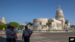 Police stand guard near the National Capitol building in Havana, Cuba, Monday, July 12, 2021, the day after protests against food shortages and high prices amid the coronavirus crisis.