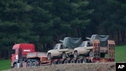  A truck, part of a convoy, carrying military pickup trucks with machine guns attached is seen on the outskirts of the village of Sugedigi, Turkey, Jan. 21, 2018. 