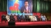 Government ministers sit under a banner depicting Cameroonian President Paul Biya during celebrations marking Biya's 86th birthday, at Yaounde Conference Center, in Yaounde, Cameroon, Feb 13, 2019.