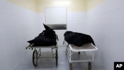 The corpses of two people who died of COVID-19 lie inside the morgue of the National Hospital Nacional, before their relatives come for them, in Itagua, Paraguay, Sept. 7, 2020.
