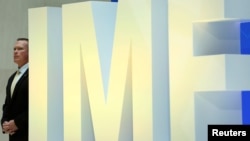 A security personnel stands next to International Monetary Fund logo at IMF headquarters in Washington, April 19, 2017. 