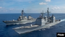 Kapal penjelajah peluru kendali kelas Ticonderoga USS Bunker Hill (CG 52), depan, dan kapal perusak rudal berpemandu kelas Arleigh Burke USS Barry (DDG 52) transit di Laut Cina Selatan. (Foto: Flickr)