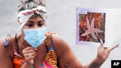 In this Sept. 2, 2020 file photo, pre-school teacher Mikki Laugier wears a protective mask as she guides students in a lesson at P.S. 15, in the Red Hook neighborhood of the Brooklyn borough of New York
