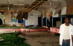An attendant at the Shamo Hotel is seen next to the site of a bomb explosion in Mogadishu, Somalia, Thursday, Dec. 3, 2009. A male suicide bomber dressed as a woman attacked a university graduation ceremony Thursday, killing at least 15 people,…