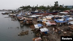 FILE - A view of temporary shelters for typhoon survivors that were constructed next to a ship that ran aground is pictured nearly 100 days after super Typhoon Haiyan devastated Tacloban city in central Philippines, Feb. 14, 2014. 