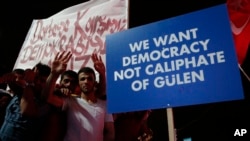 Supporters of Turkish President Recep Tayyip Erdogan hold a placard during a pro-government rally at Kizilay main square, in Ankara, Turkey, July 20, 2016.