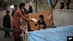 Displaced Afghans distribute food donations at an internally displaced persons camp in Kabul, Afghanistan, Sept. 13, 2021. 