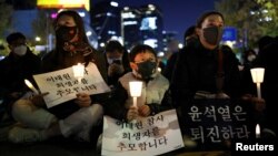 People hold placards as they attend a candlelit vigil to commemorate the victims of the crowd crush that happened during Halloween festivities, at Seoul City Hall Plaza, in Seoul, South Korea, Nov. 5, 2022. 