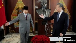 Menteri Pertahanan Prabowo Subianto bersama Menteri Luar Negeri China Wang Yi usai menandatangani buku tamu saat pertemuan di Jakarta, 18 April 2024. (Foto: Achmad Ibrahim/Pool via REUTERS)