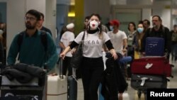 Viajeros con mascarillas provenientes de Europa llegan al aeropuerto de Sao Paulo, en Brasil, donde el 26 de febrero se reportó el primer caso de coronavirus en América Latina.