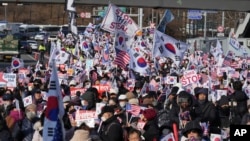Supporters of impeached South Korean President Yoon Suk Yeol stage a rally to oppose a court having issued a warrant to detain Yoon, near the presidential residence in Seoul, South Korea, Jan. 3, 2025. The letters read, "Oppose Impeachment." 