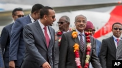 FILE - Eritrea's Foreign Minister Osman Sale, center-right, is welcomed by Ethiopia's Prime Minister Abiy Ahmed, center-left, upon the Eritrean delegation's arrival at the airport in Addis Ababa, Ethiopia, June 26, 2018.