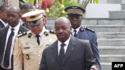 Le président du Gabon, Ali Bongo (C), passe en revue les troupes lors d'une cérémonie à Libreville le 16 août 2019 au Mausolée du pays. 