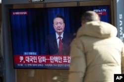 A man watches a TV screen showing the live broadcast of South Korean President Yoon Suk Yeol at the Seoul Railway Station in Seoul, South Korea, Dec. 7, 2024.
