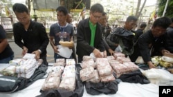 FILE - Thai policemen display intercepted drugs - 226 kilograms (498 pounds) of crystal meth and 8 kilograms (18 pounds) of heroin - during press a conference in Bangkok, Thailand, March 24, 2016. Thai police arrested 15 Malaysians as part of the operation.