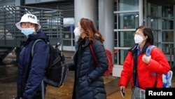 FILE - Passengers wearing masks, amid the health threat of a novel coronavirus, arrive on a direct flight from China at Chicago's O'Hare Airport, Jan. 24, 2020.