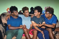 Eritrean under-20 soccer players Hermon Fessehaye Yohannes, Simon Asmelash Mekonen, Hanibal Girmay Tekle, and Mewael Tesfai Yosief talk together in a house where they are staying in Uganda.