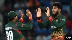 Bangladesh's Rishad Hossain (R) celebrates with his team captain Najmul Hossain Shanto after taking the wicket of India's Virat Kohli during the ICC Champions Trophy one-day international (ODI) cricket match between Bangladesh and India at the Dubai Inter