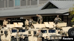 U.S. National Guard members are seen near the Wisconsin State Fair exposition center where the U.S. Army Corps of Engineers had previously built a field hospital which will be activated to treat COVID-19 patients, in West Allis, Oct. 7, 2020. 