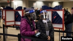 Dos personas esperan para emitir voto para las elecciones presidenciales 2020 durante la votación anticipada en Cincinnati, Ohio, EE. UU., 6 de octubre de 2020.