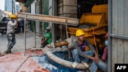 FILE - Workers rest at a construction site in Kuala Lumpur on July 3, 2020.