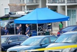 FILE - Personnel with the Federal Bureau of Investigation stage outside the apartment of Breonna Taylor as the agency executes a search warrant of the home in Louisville, Kentucky, June 19, 2020.