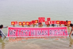 Protesters participate in a mock drowning as a signal to the world that they, as their country, need to be saved, in Nyaung-U, Myanmar, March 19, 2021.
