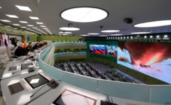 FILE - Russian President Vladimir Putin, fifth left, and other top officials oversee the test launch of the Avangard hypersonic glide vehicle from the Defense Ministry's control room in Moscow, Dec. 26, 2018.