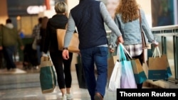FILE PHOTO: Shoppers carry bags of purchased merchandise at the King of Prussia Mall, United States' largest retail shopping space, in King of Prussia