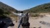 Foto ilustrasi yang menunjukkan seorang petugas perbatasan AS memeriksa seorang migran pencari suaka di dekat Dulzura, California, pada 5 Juni 2024. (Foto: AP/Gregory Bull)