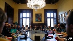 President of the Catalan parliament Carme Forcadell, center, sits with parliament representatives to discuss their next move after Spanish government announced plans to remove members of the region's pro-independence government, at the Catalonia Parliament in Barcelona, Oct. 23, 2017.