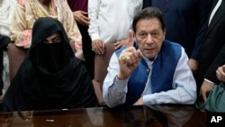 FILE - Pakistan's former Prime Minister Imran Khan, right, with his wife, Bushra Bibi, speaks to the media at an office of Lahore High Court in Lahore, Pakistan, on July 17, 2023. 