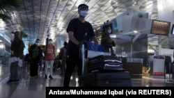Penumpang di Bandara Soekarno-Hatta di tengah pandemi COVID-19, di Tangerang, 23 Desember 2020. (Foto: Antara/Muhammad Iqbal via Reuters)
