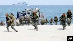 FILE - In this May 9, 2018 photo, Philippine and U.S. Marines storm a beach as part of an amphibious landing exercise during a two-week joint U.S.-Philippines exercise facing the South China Sea in the Philippines. 