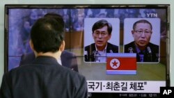 A South Korean man watches a TV screen reporting about South Korean Kim Kuk Gi, left, and Choe Chun Gil detained in North Korea, at the Seoul Railway Station in Seoul, South Korea, Friday, March 27, 2015.