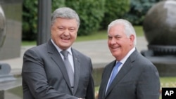 Ukrainian President Petro Poroshenko, left, and U.S. Secretary of State Rex Tillerson shakes hands before a meeting in Kyiv, Sunday, July 9, 2017. 